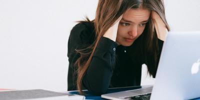 Mulher estressada olhando para um laptop — foto por Anna Shvets no Pexels